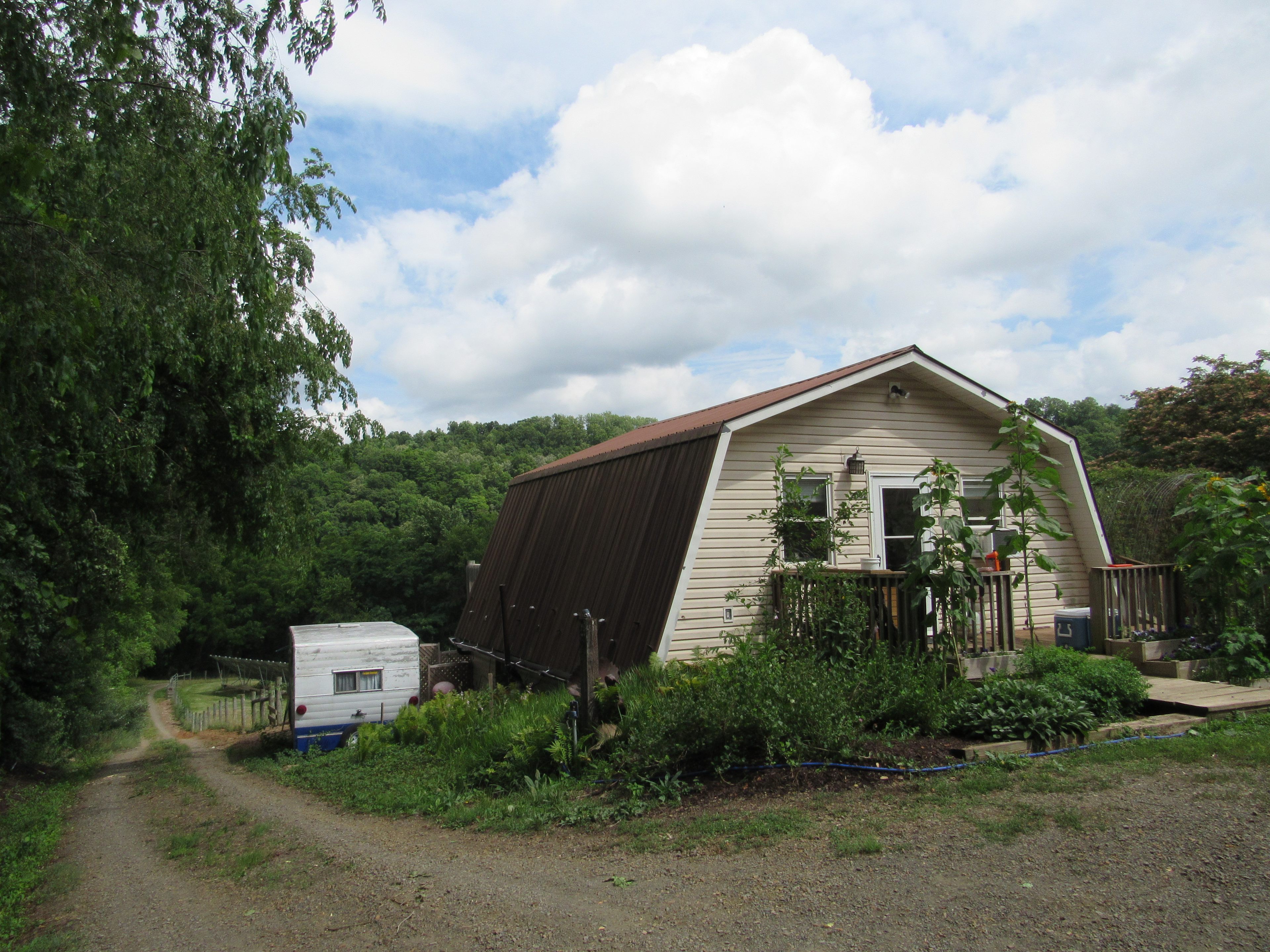 View of Lisa's house and vintage camper as you first pull onto the property. To the left is the road that leads to the river and campsite. 