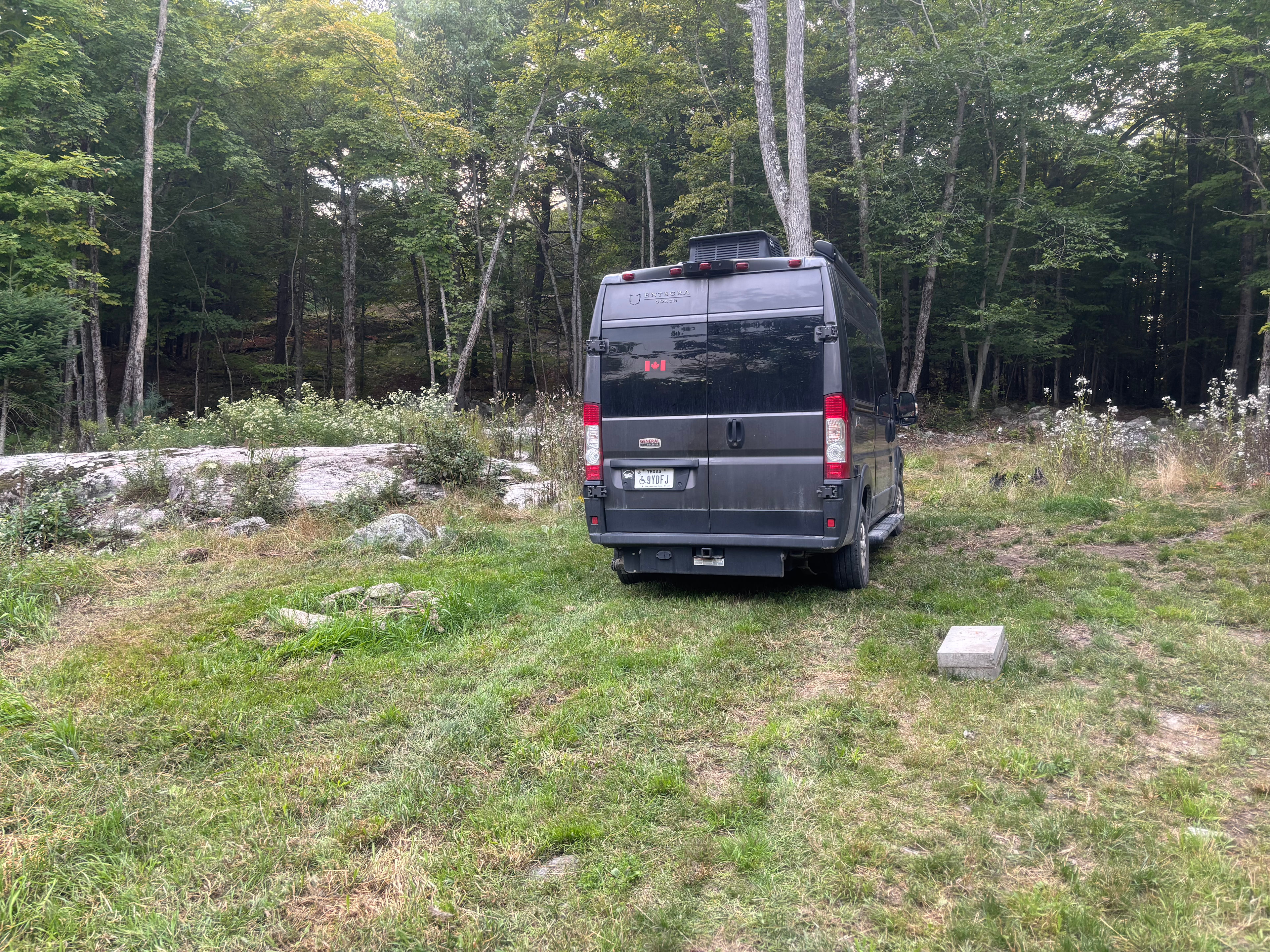 to the immediate left of the van is a firepit. I squeezed in between the very heavy concrete blocks to the immediate right of the van. Could not turn around. Got stuck in the mud where the van is shown, but worked my way out.