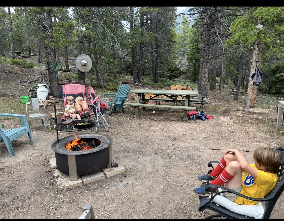 Fire/Cook Area. Bluetooth speakers, plug in lights, picnic tables, camp cookware, chairs, and hose to put out the fire. To use the hose, the water switch is in the screened in porch in the back corner near the door to the cabin. There is a fire ban, so please be careful 