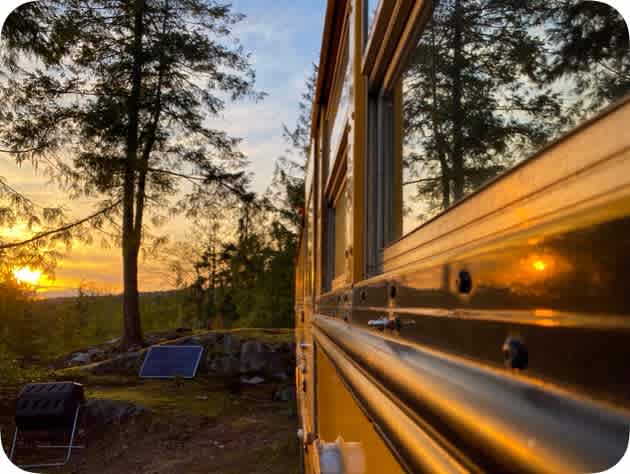 The side of the bus reflecting the evening light