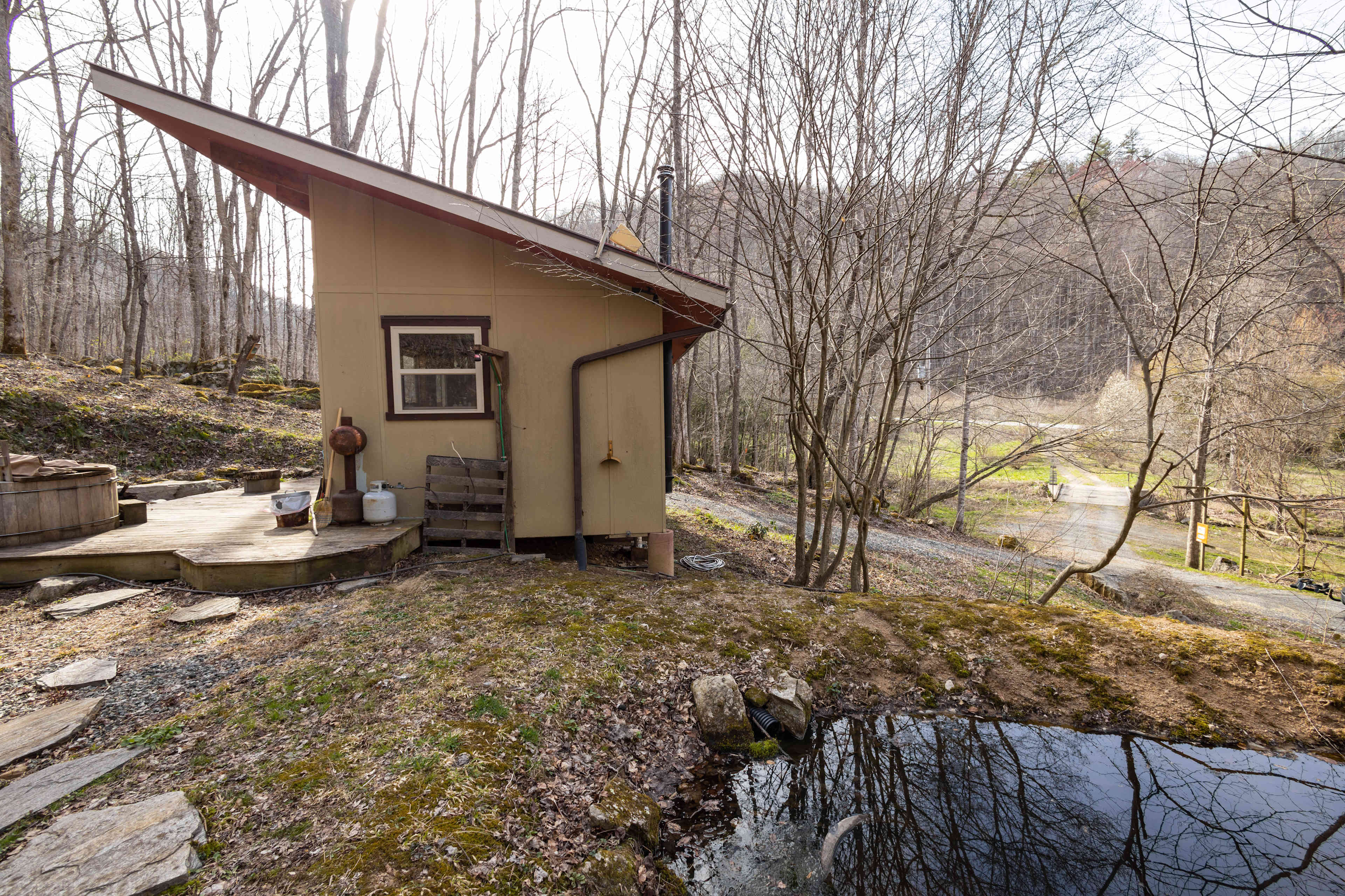 There is a small pond beside the tiny home.