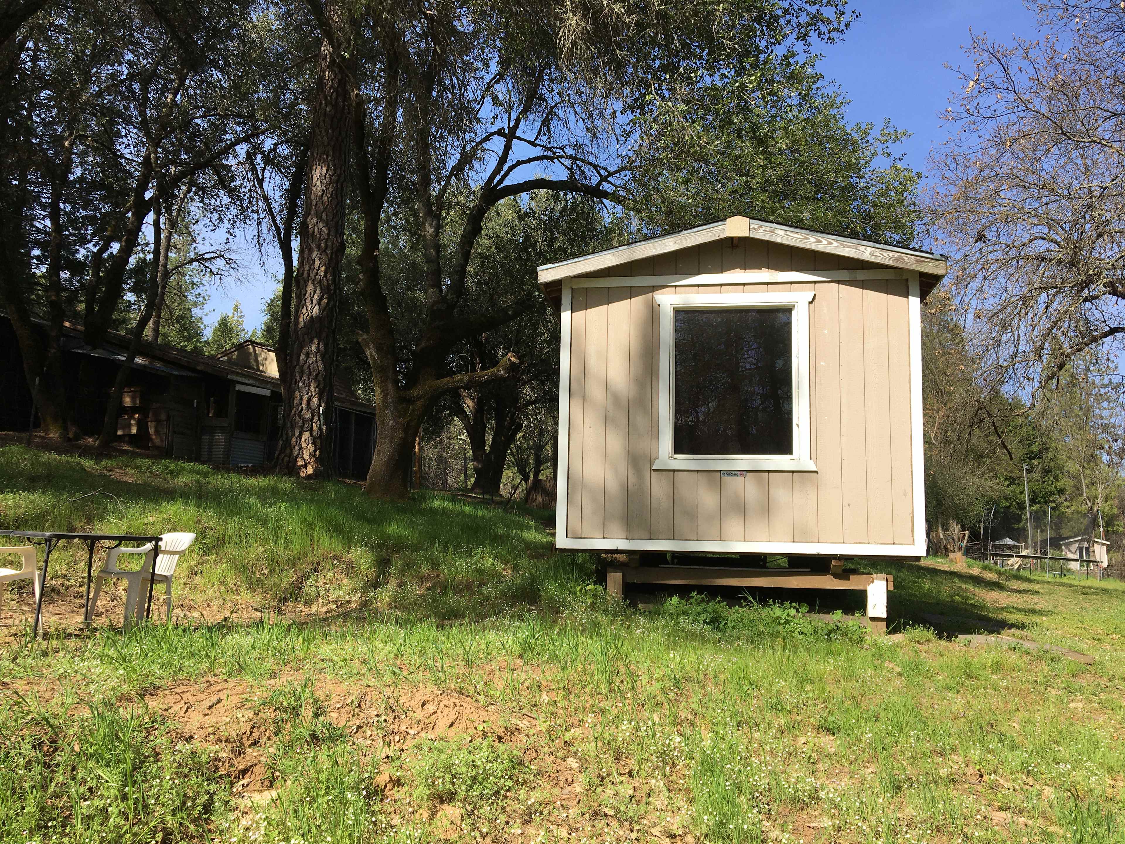 The back of cabin 2 with table area and overflow tent site for cabin 2.