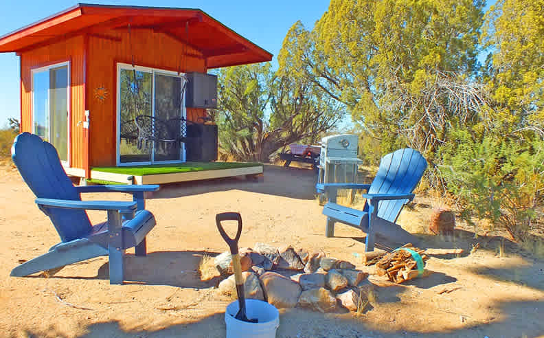 'Glassy glamping' is our newest upgrade for Hacienda Haven.  A weather tight insulated building around a queen size bed with 3 double glazed sliding doors to further assure your camping enjoyment. A small wash basin with running water and now a small refrigerator, propane hot plate, "kitchenette" is included. A Kureg coffeemaker is there with a few K-cups. Notice the swinging hammock chairs too.