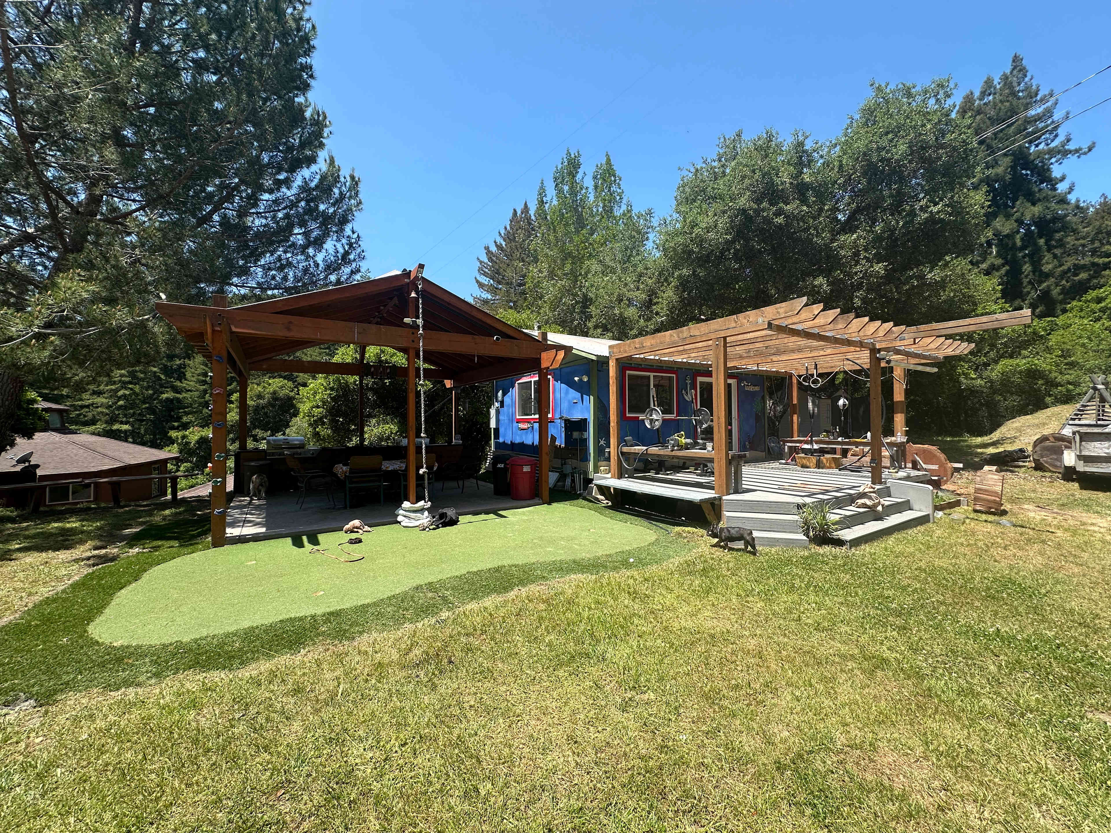 The bungalow has a porch outside along with a covered kitchenette and a table with seating for 6. There’s a putting green with clubs and balls and a climbing rope. 