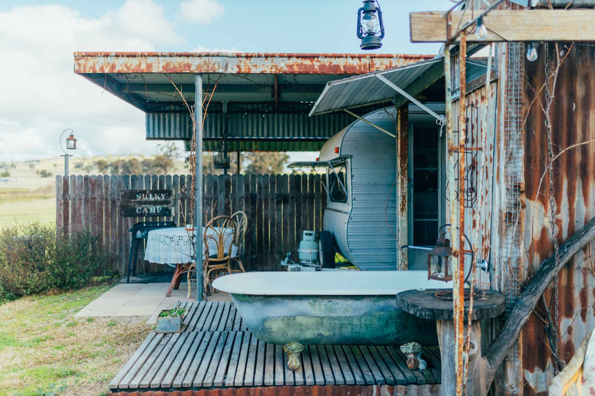 outdoor bath with caravan in the background