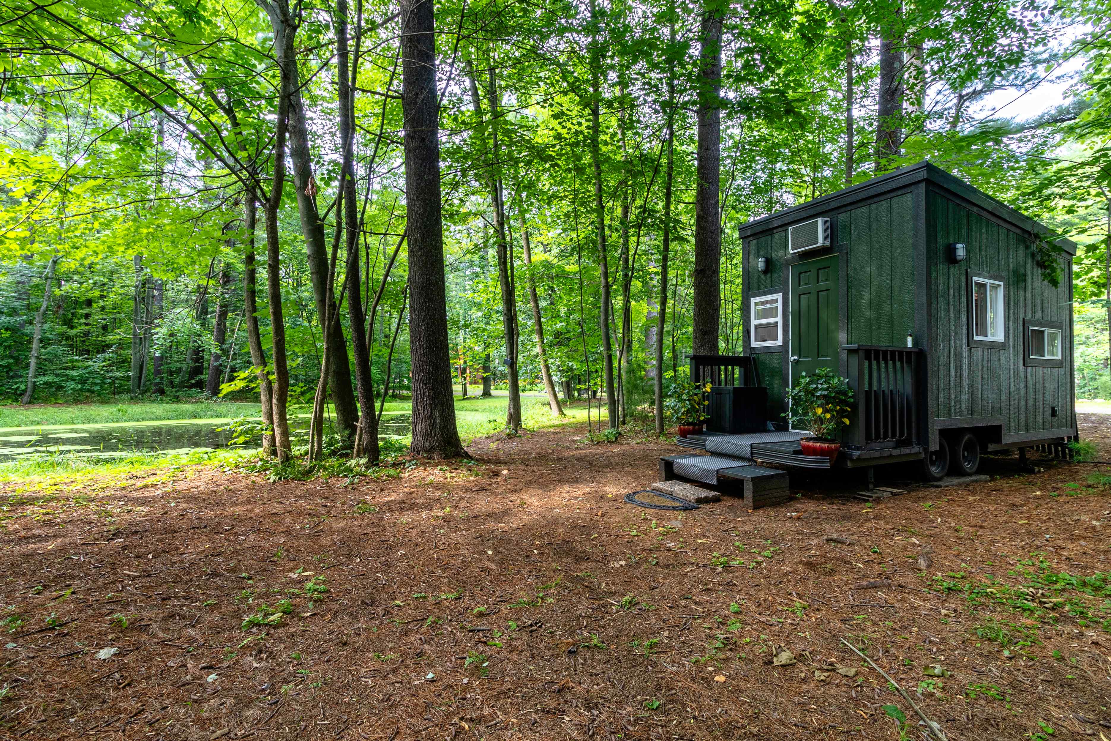 Beautiful, brand new tiny home. Bright, private, air conditioned in summer and cozy warm in the winter. Use the inside toilet on those cold nights if you choose! Cook in the fully functional kitchen and eat or work on the kitchen bar while gazing out a large window and watch the wildlife. Enjoy your private patio and pond. Smell the pines, hear the variety of wildlife while you disconnect.