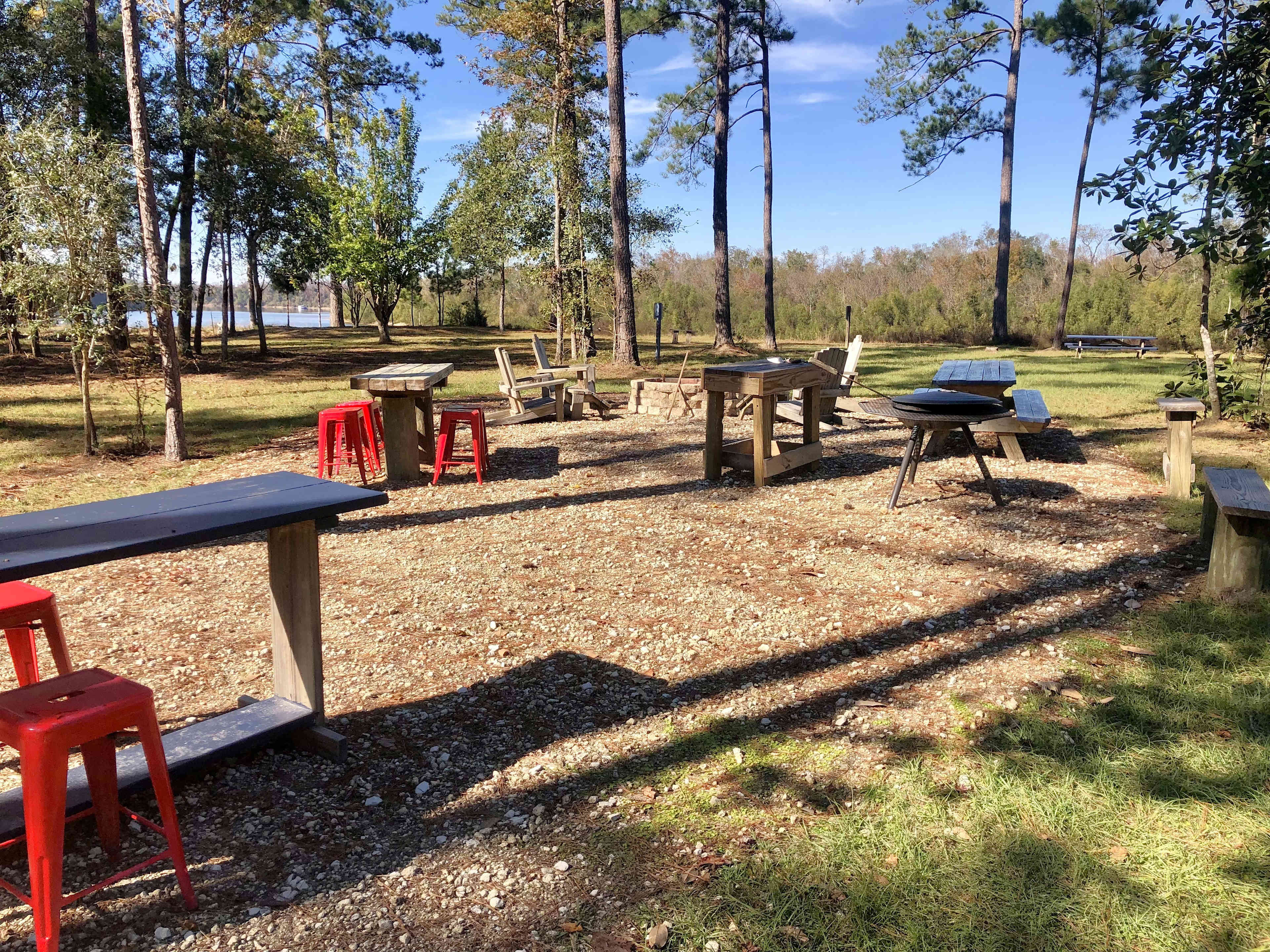 Site 2 living area with lots of wood furniture, charcoal grill, and firepit, along with fabulous river views!