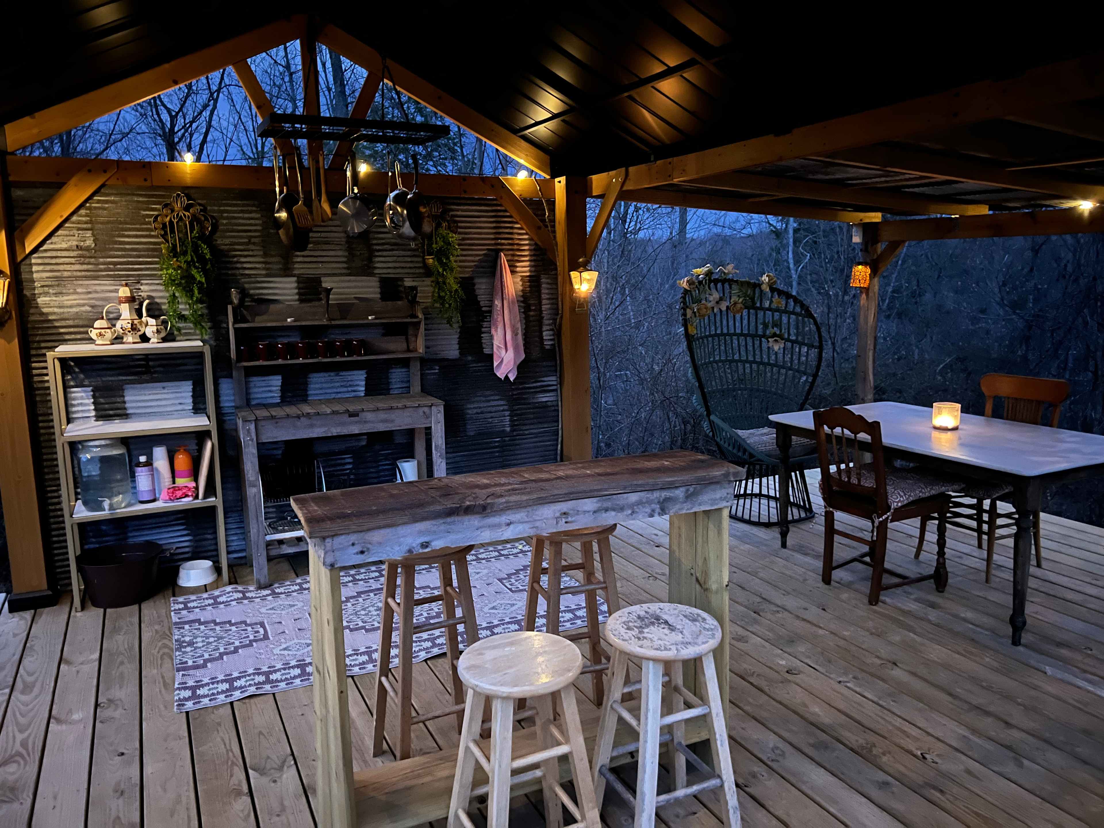 Outdoor kitchen area with farm table and bar
