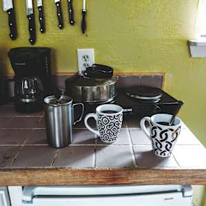 There is a fridge and a little electric stove in the kitchen area.