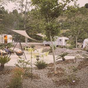 Camp Candide is the communal area for all the campers. It's surrounded by drought resistant plants and shaded by a few trees and 2 shaders hung up. A nice breeze flows through keeping it cool.