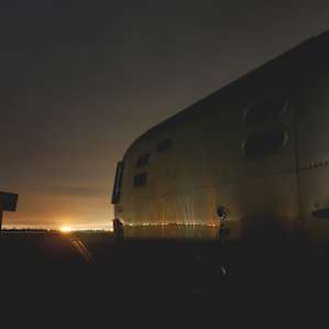 RV parking available on an old tarmac with a view of city lights way out in the distance