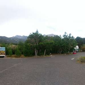 Panoramic in front of the camping signs of the camp host and a few sites.