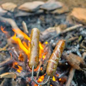 Cooking brats over the fire-pit, for a great dinner in the tent!