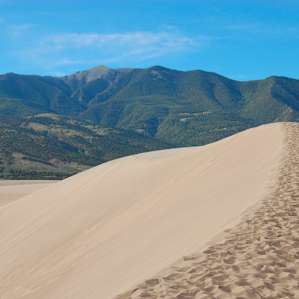 The dunes surrounded by lush green mountains.