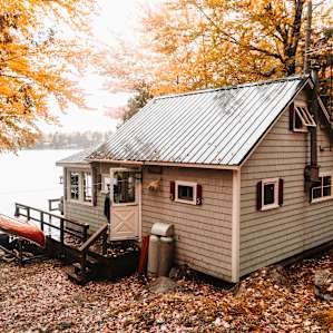 The view of the house from the road.
The house does not have an outhouse but rather an outhouse across the street from the house.
The exterior of the outhouse is made to match the color of the cottage.