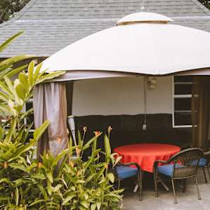 The deck and table with canopy covering for shade outside the yellow cottage