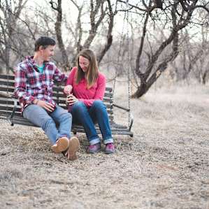 A porch swing hangs from a sturdy mesquite branch.