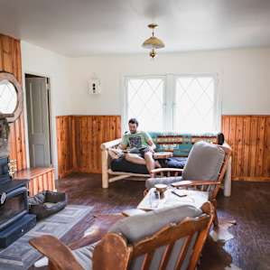 The living room is extremely cozy with lots of comfy chairs, couch, fireplace, and even a little breakfast nook. There are big bright windows looking out into the woods which makes it a great place to read or just relax.