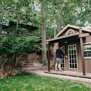 A view of the tiny cabin with the main home in the background.