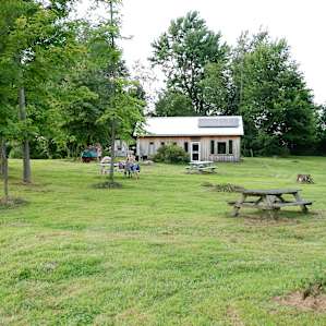 The cabin is close to the pond and has three picnic tables to eat at