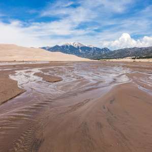 Snow melt from the mountains creates a beach area at the base of the dunes (this occurs between April and early June with the strongest flow typically late May to early June) in Great Sand Dunes National Park and Preserve.