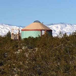 Purty Yurty against the snow-covered mountains of Joshua Tree.