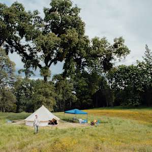 The glamping tent is settled quite nicely in this expansive meadow.