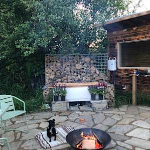 Outdoor fire pit featuring cute dog.