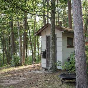 The outhouse is tucked in the trees and is clean and perfectly maintained