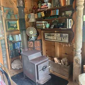Wood stove to keep you warm surrounded by books galore. Even on a rainy day you would never get bored. Nice touches like sock drying line by wood stove. And all the wood is provided!