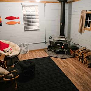 Living room with comfy seats and wood stove.