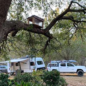 Our camper for thr night as seen from the front of the house. We didn’t bother leveling it. Quiet night with a pretty sunrise through the trees.