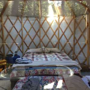 Inside the yurt with twin inflatable mattress at the foot of the bed.