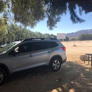 Parked in the campsite, with the picnic bench and fireplace to the side of the car