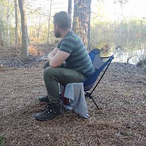 Enjoying the view of the pond by a campfire