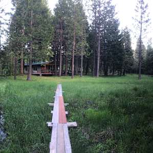 View of the cabin from across the meadow. The boardwalk leads to the bathroom & other cabins.