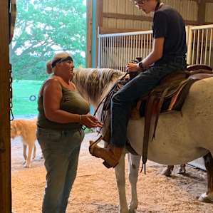 Sandy helping my son adjust his stirrups.
