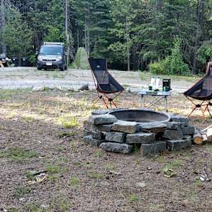 Fire-pit with wood. The water pump (electric) is located just next to the picnic table.