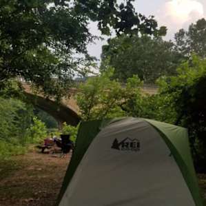 The view of our camp site set up - we pitched our tent under the tree for shade and cover from rain (less grass, but fine w/ inflatable sleeping pads). The picnic area and fire pit were just beyond that and the stream is between the picnic area & the bridge.