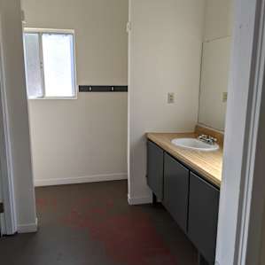 Full bathroom with double sinks and dressing area to back right.