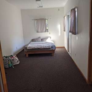 Second bedroom with queen sized bed, door to deck and attached half bathroom.
