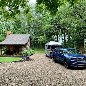 A level gravel driveway, with a 30A hookup on one side and a lovely artist's cabin on the other!