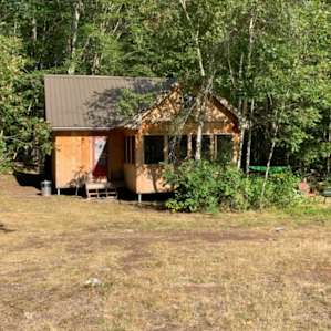 Cabin between a field and the woods