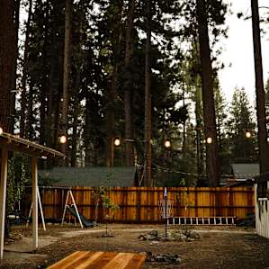 Common space with disc golf, playground, globe lights, and a picnic table