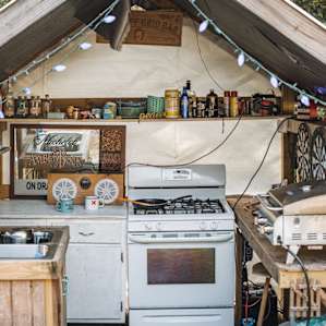 Covered outdoor kitchen including a stove, griddle, and sink.