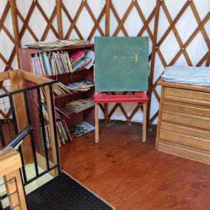 The yurt has a collection of kids books.