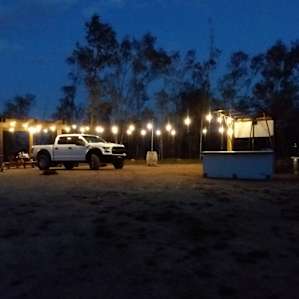 Well lit, with picnic table, countertops for prep and cooking, and sink and bathroom located behind the "kitchen" area.