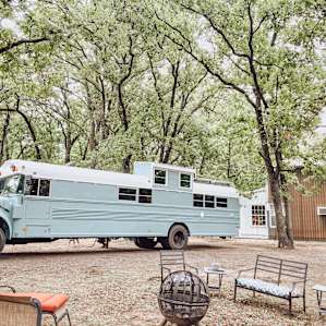 Nestled between trees and right next to a cozy fire pit!