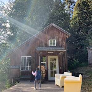 Kid is dancing in front of the cabin entrance.