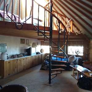 Standing at the table looking at the loft and full size bed.